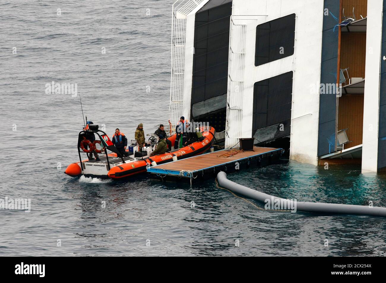 Une Garde côtière RHIB (bateau gonflable à coque rigide) attend près de la  poupe du paquebot de croisière Costa Concordia au large de la côte ouest de  l'Italie à l'île de Giglio