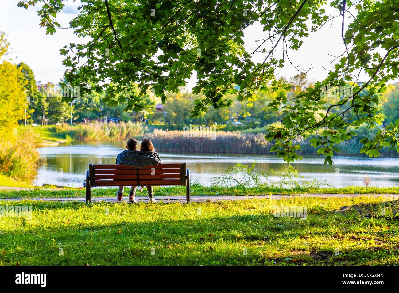 Couple assis sur un banc dans le parc Szczesliwicki (parc Szczęśliwicki), district d'Ochota, Varsovie, Pologne Banque D'Images