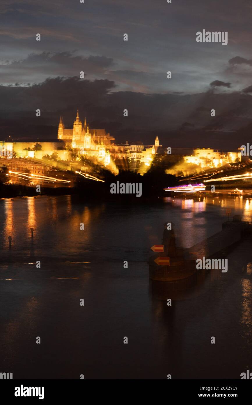 Psychédélique, paysage urbain flou de Prague illuminé la nuit avec la rivière Vltava et la cathédrale Saint-Vitus Banque D'Images