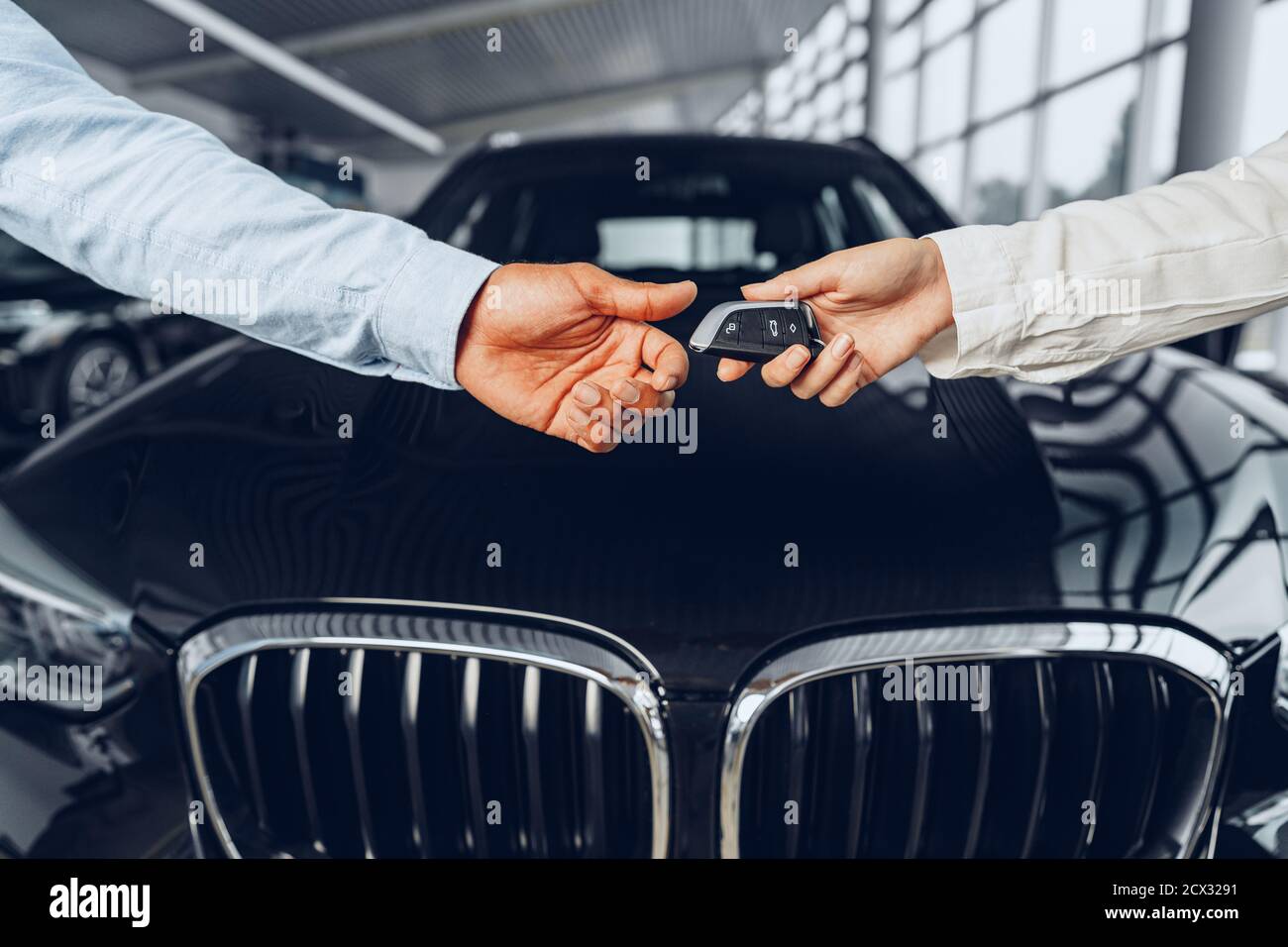 Le vendeur de voiture et l'acheteur de la poignée de main à la concession  de voiture contre un nouvelle voiture Photo Stock - Alamy