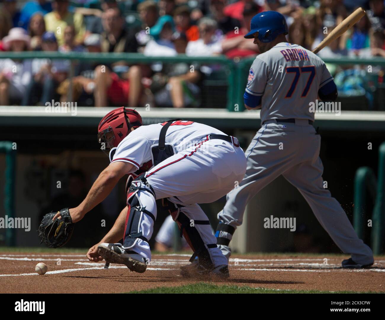 Atlanta Braves Catcher Evan Gattis L Chases Down A Wild Pitch In Front Of The New York Mets Andrew Brown During The First Inning Of Their Mlb Spring Training Baseball Game In Atlanta Braves Catcher Evan Gattis L Chases Down A Wild Pitch In Front Of The New York Mets Andrew Brown During The First Inning Of Their Mlb Spring Training Baseball Game In