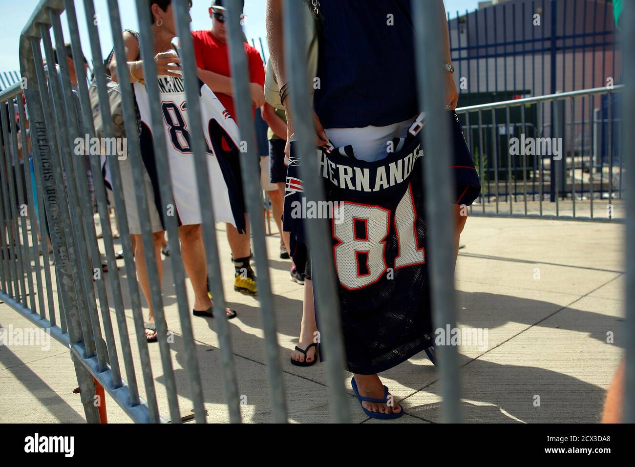 Fans wait in line behind security barriers to exchange jerseys of former  New England Patriots player Aaron Hernandez at the club's merchandise shop  in Foxborough, Massachusetts July 6, 2013. The Patriots offered