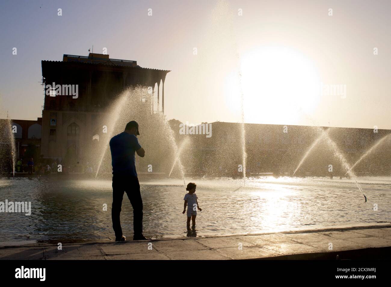 Palais Ali Qapu et fontaines publiques sur la place Naqsh-e Jahan. Place de l'Imam, ville d'Isfahan, Iran. Père et enfant iraniens Banque D'Images