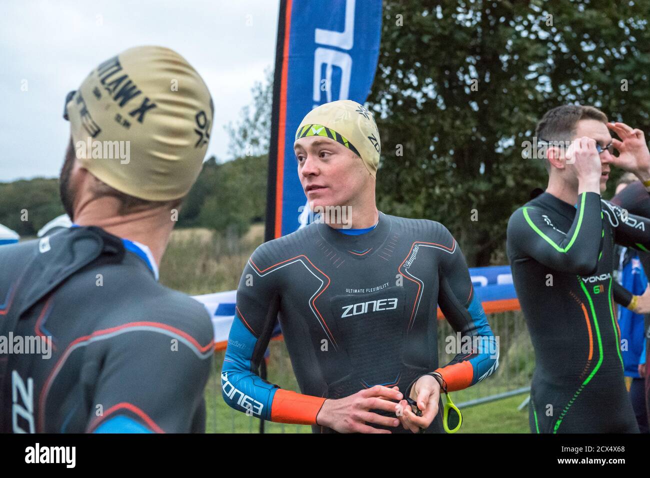 Les athlètes professionnels hommes d'élite se préparant à la première épreuve, la natation, au dernier triathlon de l'année dans leurs combinaisons humides. Banque D'Images