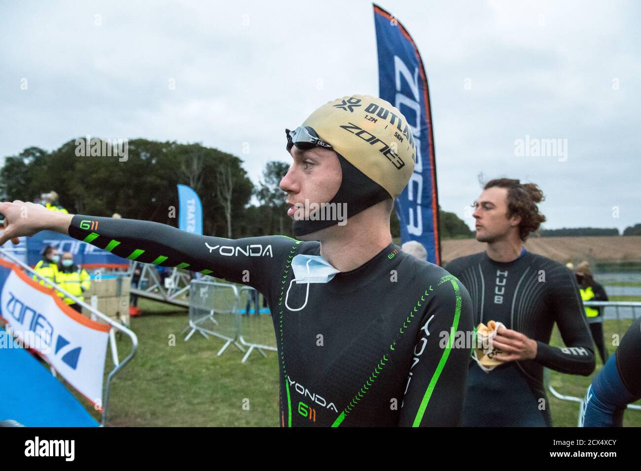 Les athlètes professionnels hommes d'élite se préparant à la première épreuve, la natation, au dernier triathlon de l'année dans leurs combinaisons humides. Banque D'Images