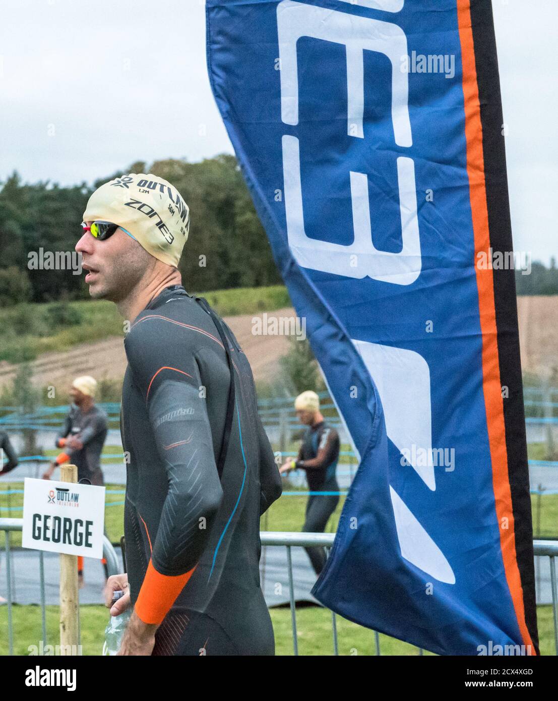 Les athlètes professionnels hommes d'élite se préparant à la première épreuve, la natation, au dernier triathlon de l'année dans leurs combinaisons humides. Banque D'Images