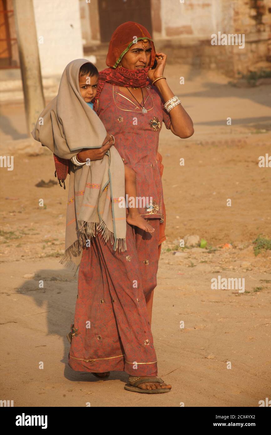 Femme indienne au téléphone à sari avec enfant dans les armes. Jodhpur, Rajasthan, Inde Banque D'Images