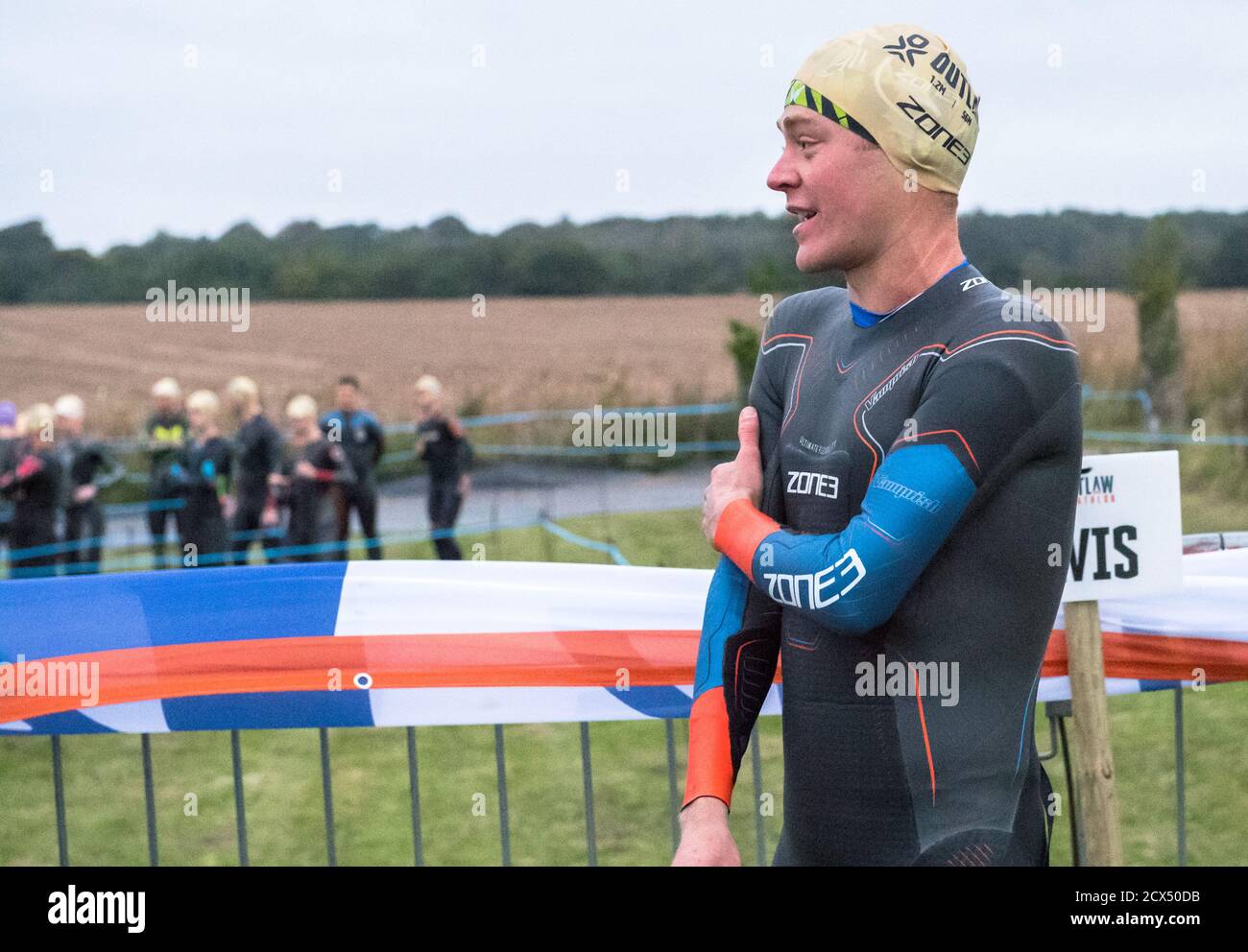 Les athlètes professionnels hommes d'élite se préparant à la première épreuve, la natation, au dernier triathlon de l'année dans leurs combinaisons humides. Banque D'Images