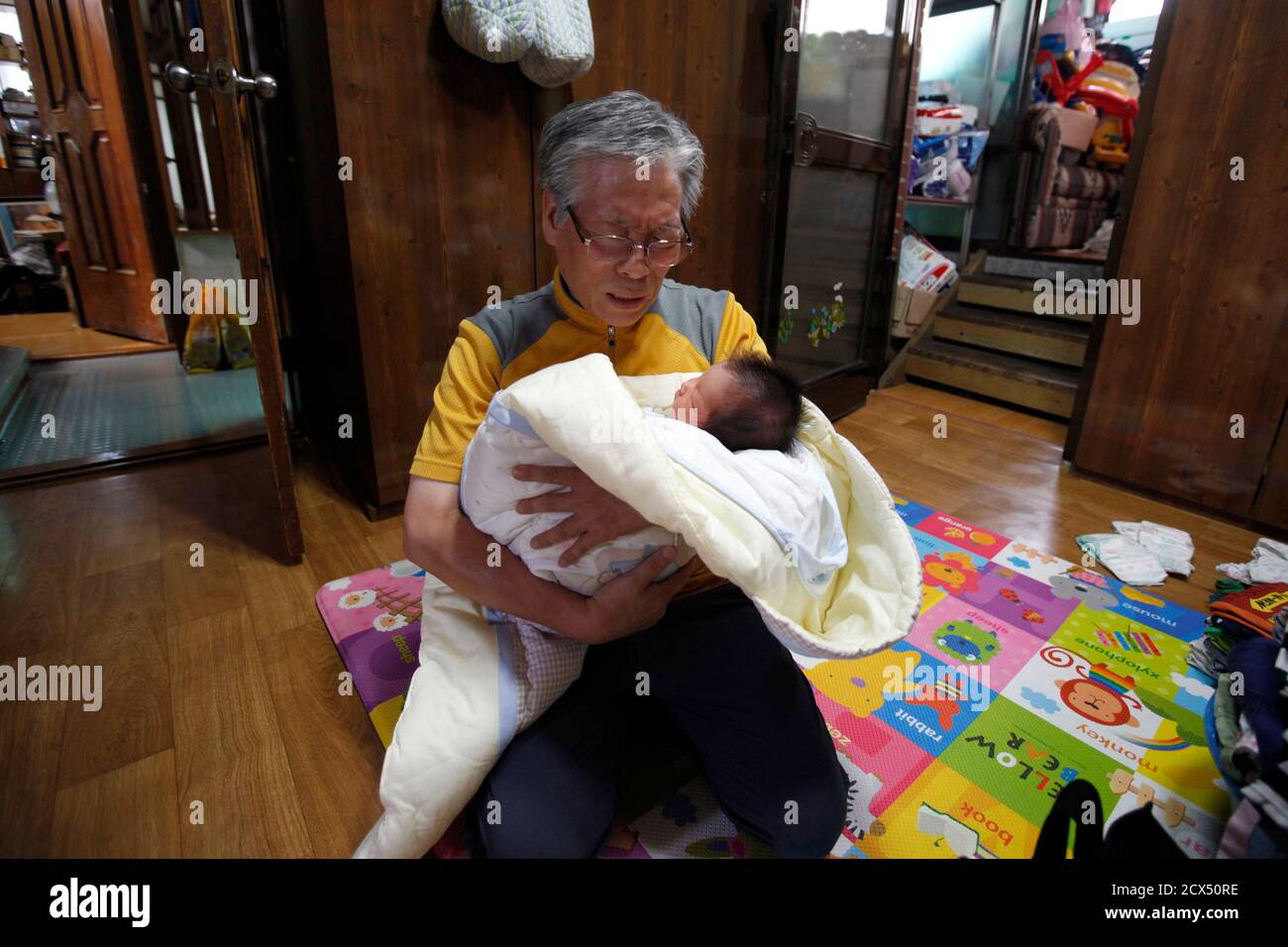 South Korean pastor Lee Jong-rak holds an abandoned baby boy as he prays at  Joosarang church in Seoul September 18, 2012. The South Korean pastor who  runs a "baby box" where mothers