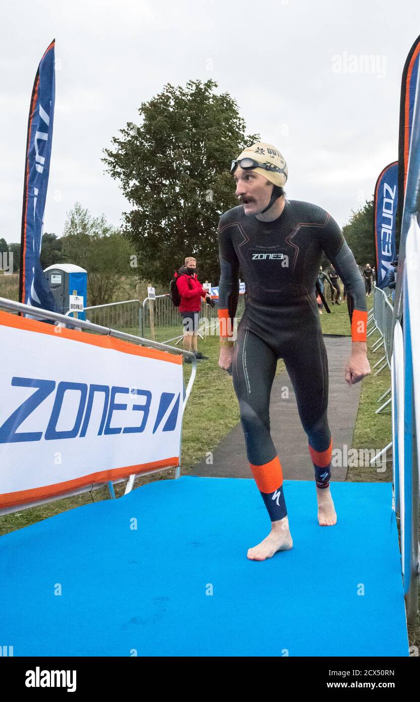 Les athlètes professionnels hommes d'élite se préparant à la première épreuve, la natation, au dernier triathlon de l'année dans leurs combinaisons humides. Banque D'Images