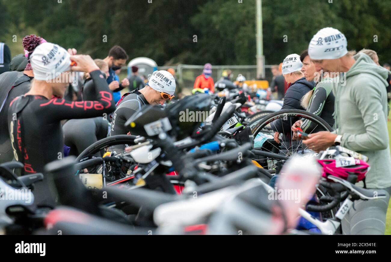 Athlète féminine, se préparant pour le dernier événement de l'année au triathlon Thoresby Park X Outlaw portant leurs combinaisons humides dans le parc de transition. Banque D'Images