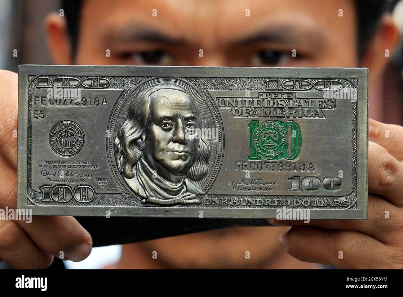 Un vendeur tient une boucle de ceinture avec des gravures de devise  américaine, qui est vendu pour 500 pesos (11 $), sur un marché à  Divisioria, le métro Manille le 23 octobre