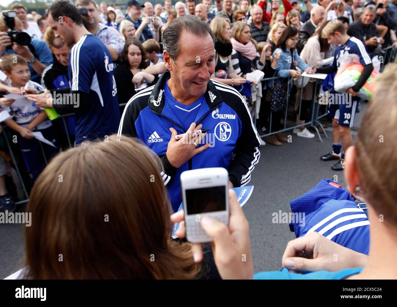 Schalke 04's new coach Huub Stevens (C) speaks to supporters as he signs  autographs after a training session in Gelsenkirchen, September 27, 2011. Schalke  04 have appointed Dutchman Huub Stevens, who had