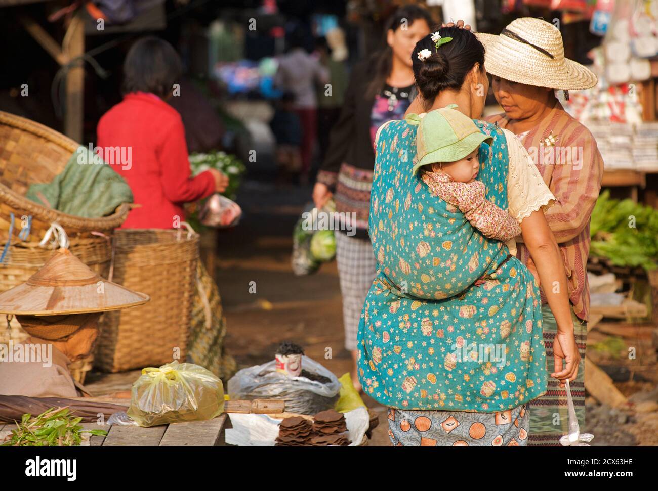 Femme birmane exerçant son bébé. Shopping au marché de Hsipaw, Birmanie. Myanmar Banque D'Images