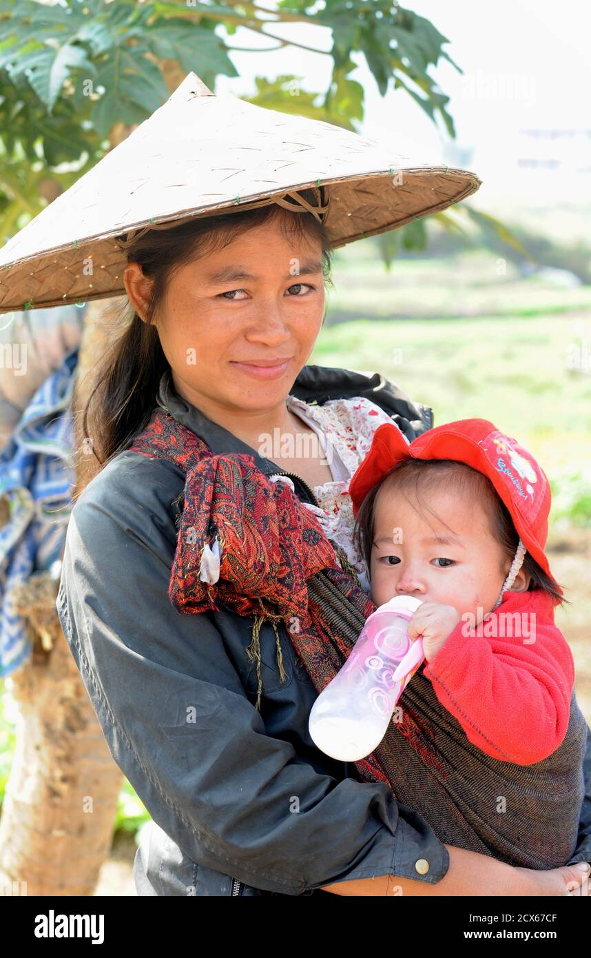 Lao femme avec enfant, Luang Prabang, Laos Laotien. Image culturellement significative : le chapeau conique est originaire d'Asie et est courant au Laos Banque D'Images