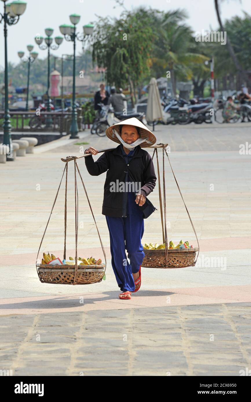 Négociant de rue vietnamien avec des produits. Hoi an, Vietnam Banque D'Images
