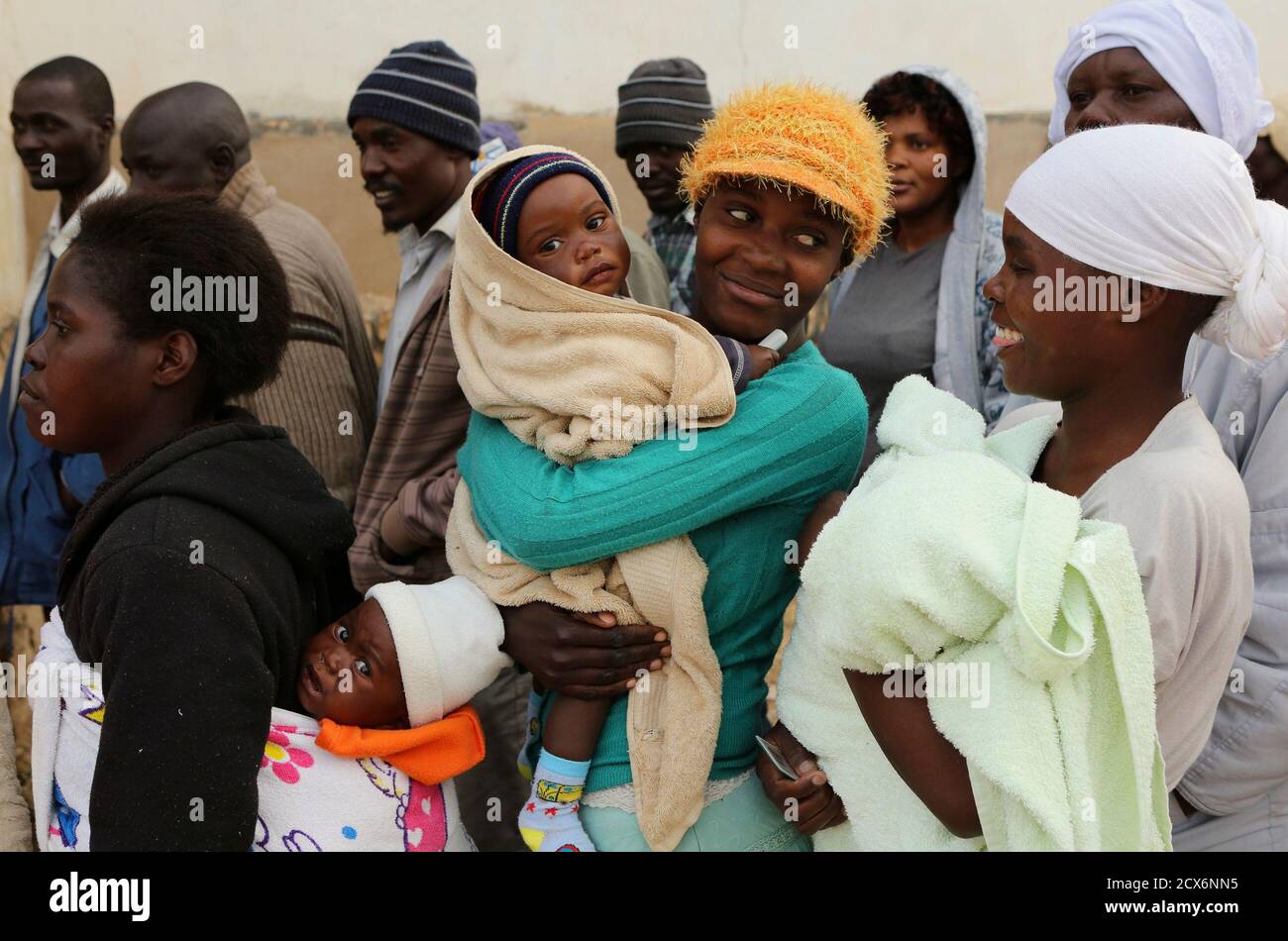 Zimbabwean women react as they wait to casts their votes at a polling  station in Domboshava, about 45 km (28 miles) north of Harare July 31,  2013. Zimbabweans voted in large numbers