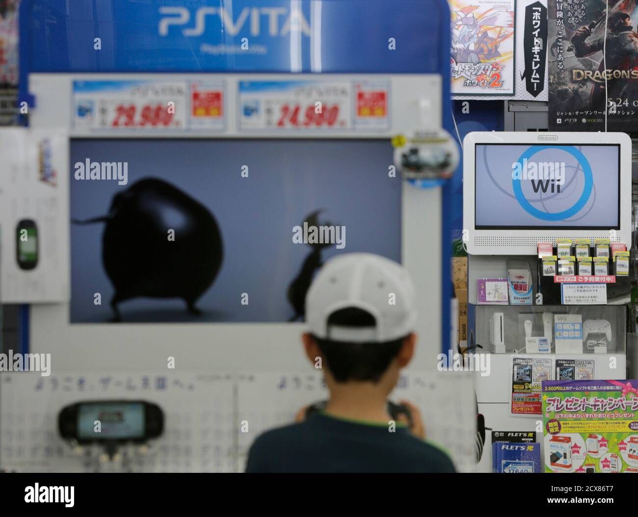 The logo of Nintendo Co's Wii game consoles are seen as boy tries out a  Sony's PlayStation Vita handheld gaming device at a Yamada Denki  electronics retail store in Tokyo June 4,
