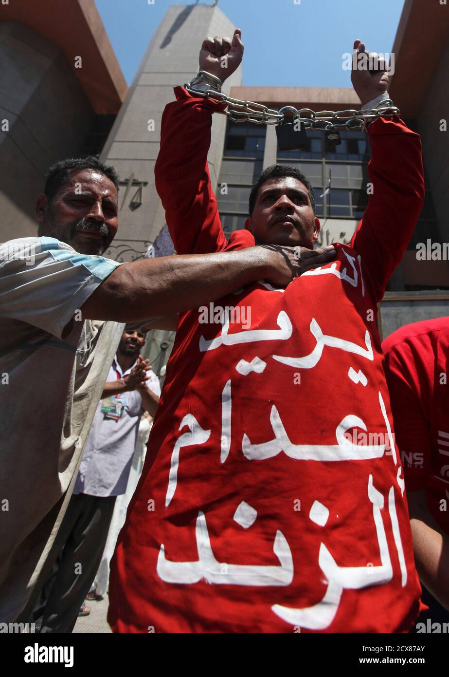 A supporter of Egypt's first Islamist President Mohamed Mursi is dressed in  a red attire and has his hands in chains and locks during a protest against  military rules and members of