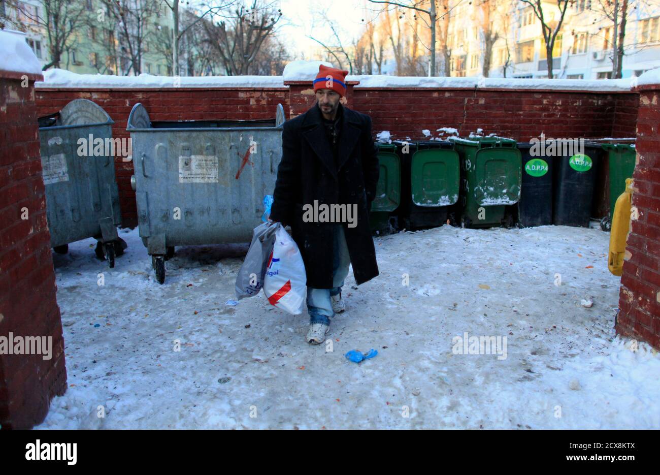 Homeless man Aurel Zugravu, 42, who refused to go to a community shelter,  leaves after picking through garbage bins in Bucharest February 1, 2012.  Local police and authorities are trying to relocate