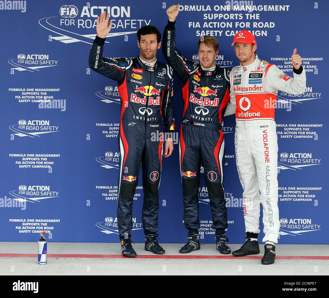 Red Bull Formula One driver Mark Webber (L) of Australia, team mate  Sebastian Vettel (C) of Germany and McLaren Formula One driver Jenson  Button of Britain wave after the qualifying session of