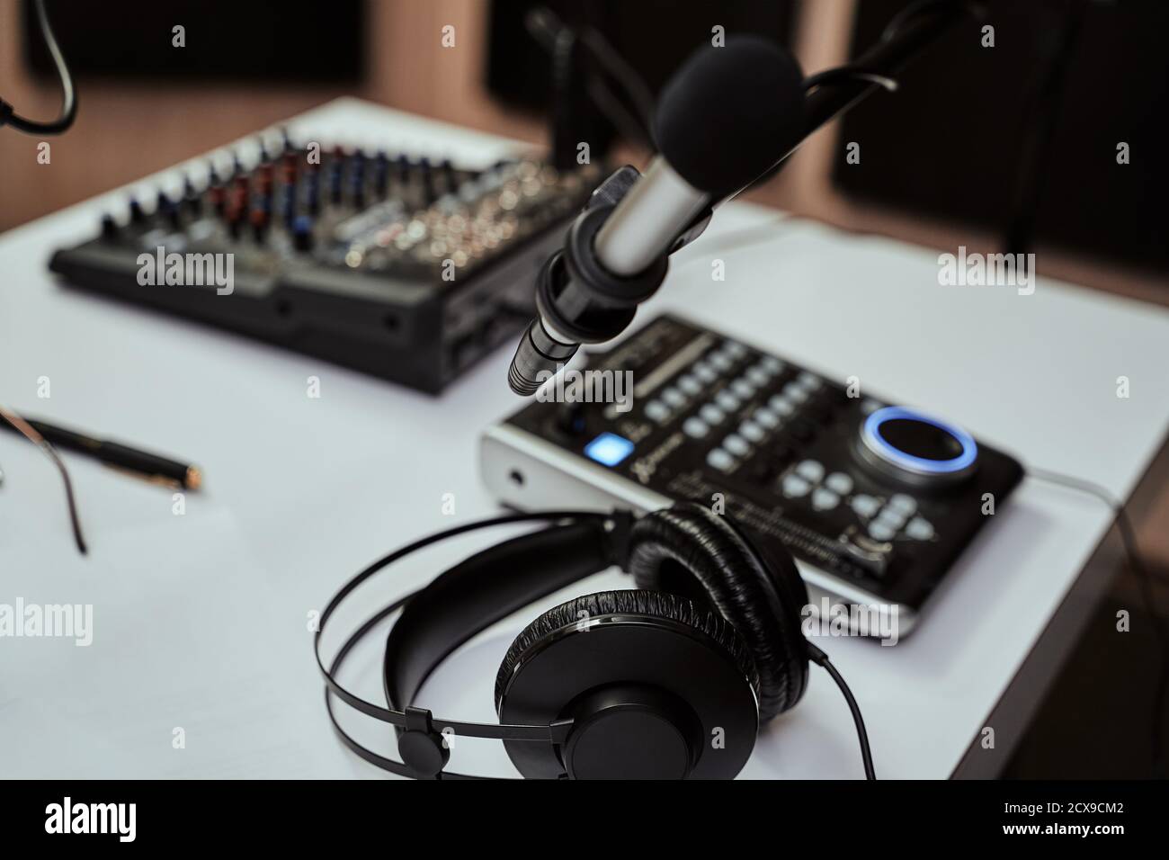 Lieu de travail de l'hôte radio. Gros plan des écouteurs, du microphone et  du bureau de mixage du son sur la table dans un studio d'enregistrement ou  une salle de diffusion Photo