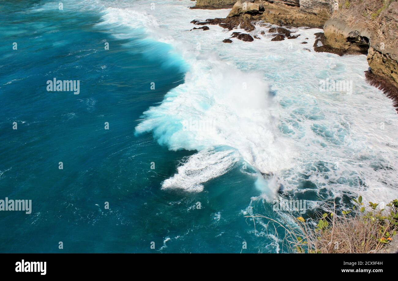 Vagues s'écrasant sur des rochers dans des eaux bleu clair de l'océan à Nusa Penida, Indonésie Banque D'Images