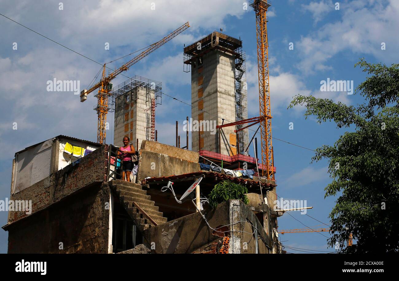 A Woman Enters Her House With Cranes And Construction Work For The Rio 16 Olympic Park Seen In The Background At The Vila Autodromo Favela In Rio De Janeiro January 28 15