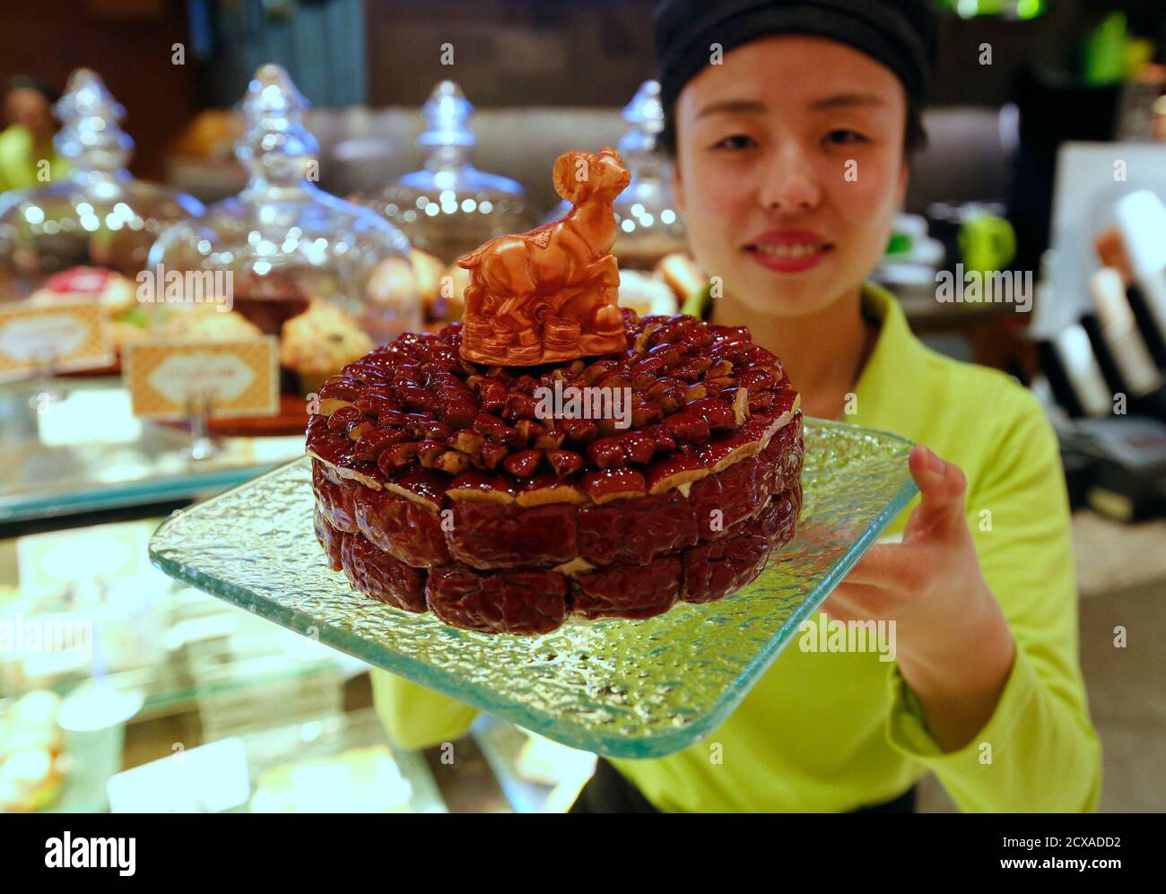 Une Serveuse Pose Avec Un Gateau Decore D Un Chocolat En Forme De Chevre Qui Est Peint Avec De La Poudre D Or Comestible Pour Celebrer Le Prochain Nouvel An Lunaire Chinois Lors D Une Une Serveuse Pose Avec Un Gateau Decore D Un Chocolat En Forme De Chevre Qui Est Peint Avec De La Poudre D Or Comestible Pour Celebrer Le Prochain Nouvel An Lunaire Chinois Lors D Une