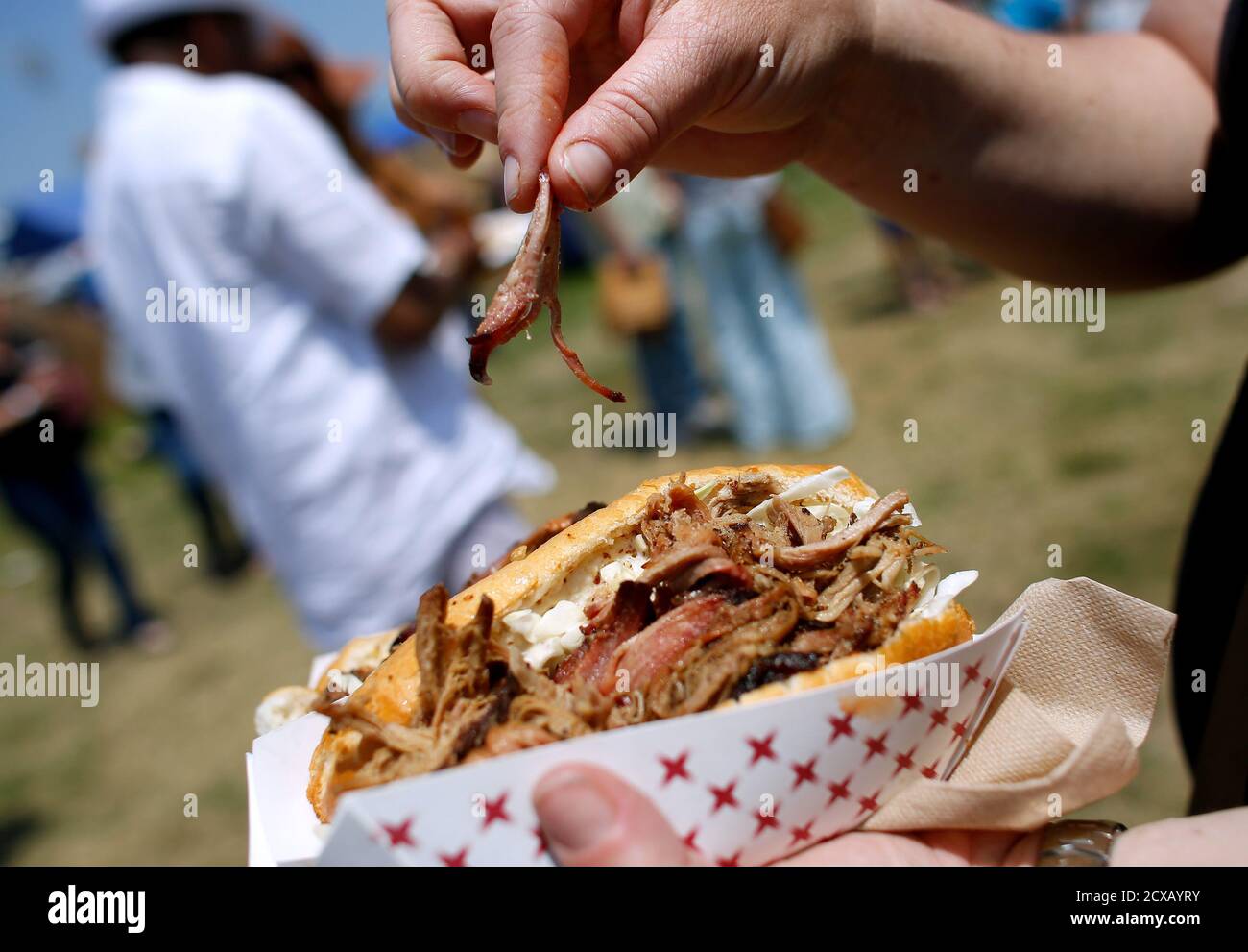 A Festival Goer Picks At Her Cochon De Lait Po Boy During The First Day Of The New Orleans Jazz And Heritage Festival In New Orleans Louisiana April 25 14 Thumping Beats Flowed A Festival Goer Picks At Her Cochon De Lait Po Boy During The First Day Of The New Orleans Jazz And Heritage Festival In New Orleans Louisiana April 25 14 Thumping Beats Flowed