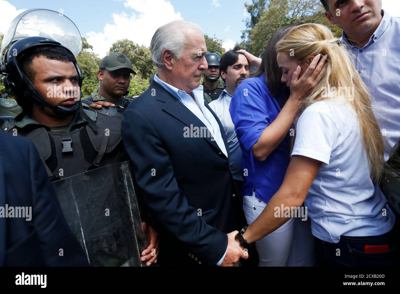 Former Colombia's president Andres Pastrana (C) holds the hand of Lilian  Tintori (R) wife of jailed opposition leader Leopoldo Lopez, outside the  military prison of Ramo Verde at the outskirts of Caracas