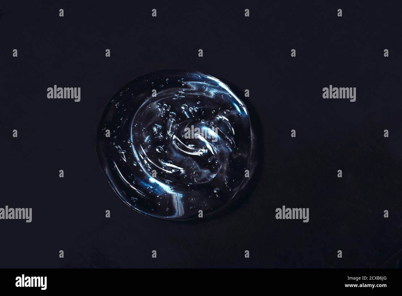 Masque cosmétique en gel noir gel liquide transparent texture sérum arrière-plan noir Banque D'Images