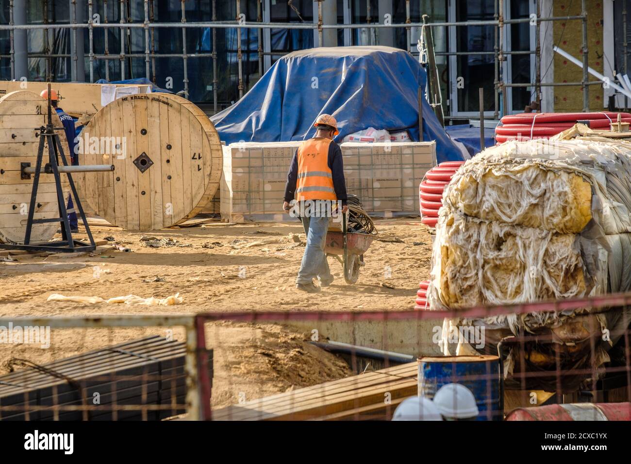 Moscou. Russie. 06 septembre 2020 UN constructeur en uniforme et un casque de protection sur un chantier transporte les matériaux de construction dans un chariot Banque D'Images