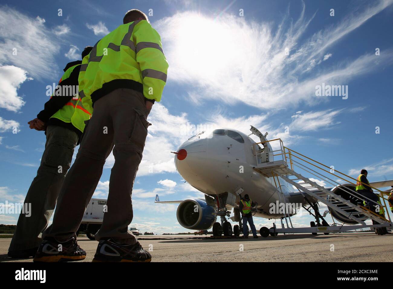 Bombardier employees look at the CSeries aircraft, after its first test