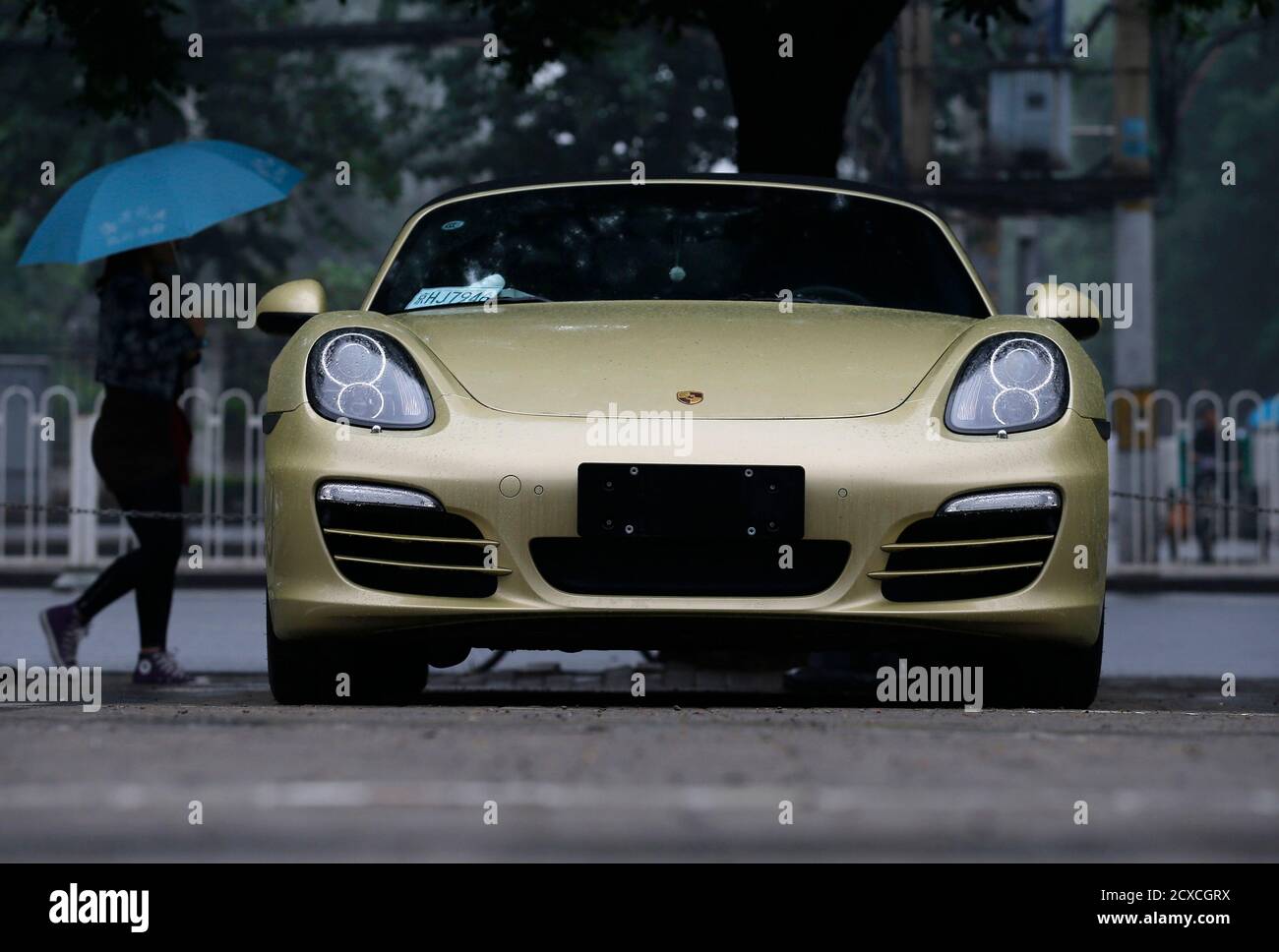 A Porsche is parked at a parking lot of a shopping mall in the rain in  Beijing June 5, 2013. China has become a crucial market for makers of  luxury cars, with