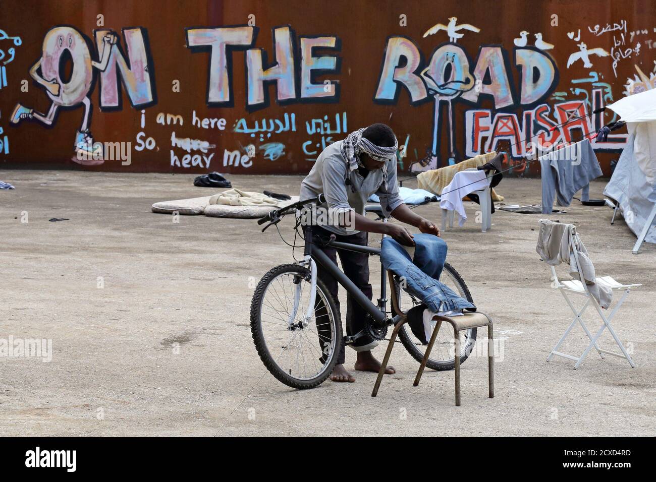 A migrant dries his pants on a chair in a squat opened by activists from  the No Borders UK network in a former recycling factory in Calais August 2,  2014. More than