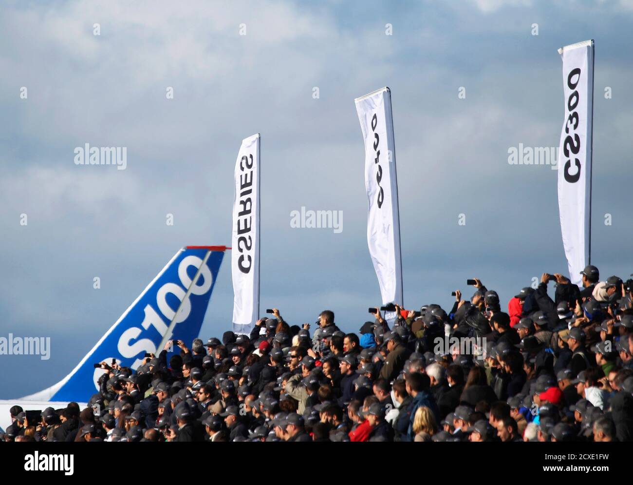 Bombardier employees and guests watch as the CSeries aircraft taxis