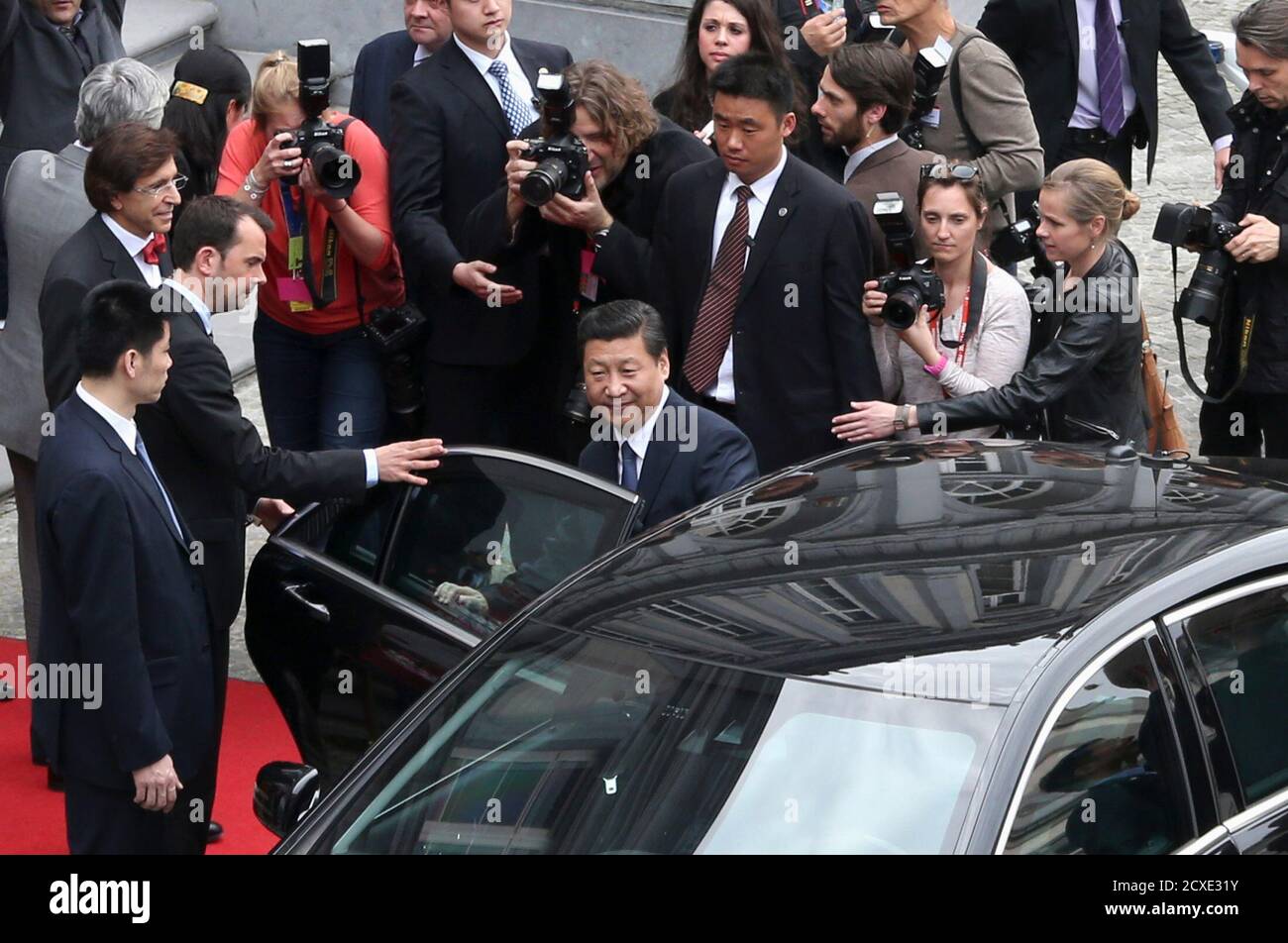 Le président chinois Xi Jinping (C) entre dans sa voiture alors qu'il  quitte une réunion avec le Premier ministre belge Elio Di Rupo (L, en nœud  papillon) au Palais Egmont à Bruxelles