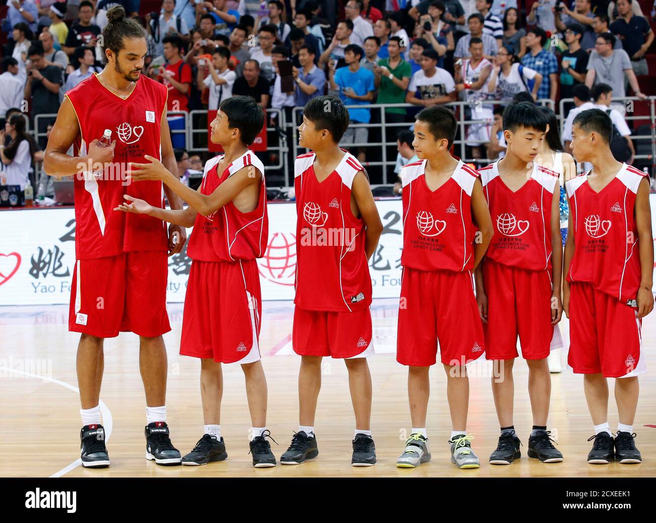 A player from a primary school basketball team offers water to Chicago Bulls  center Joakim Noah after a charity basketball match between the NBA  All-star team and Chinese National team in Beijing
