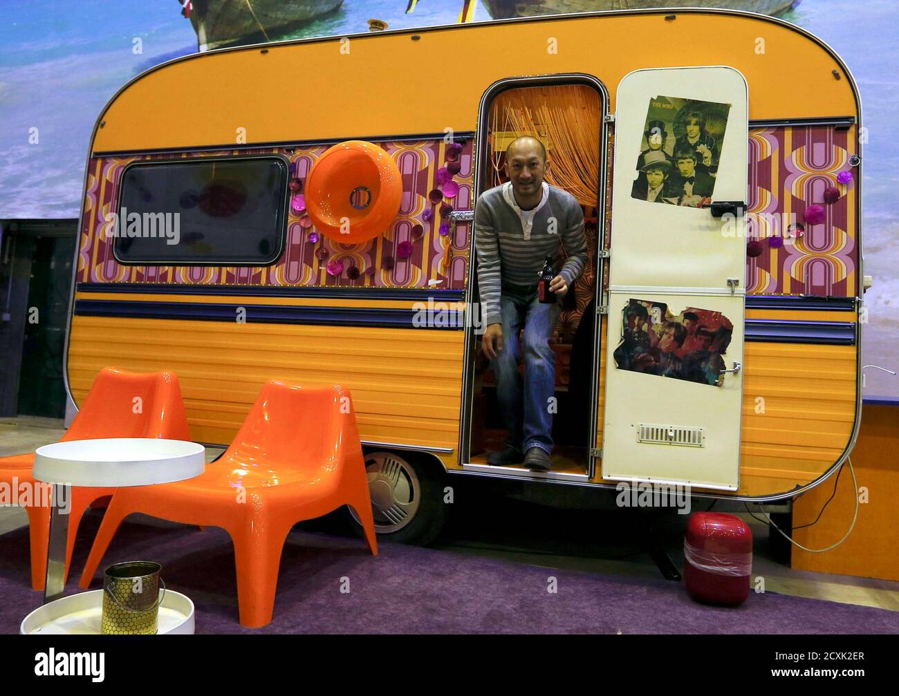 A man leaves "Flower Power" , a vintage camping caravan that was converted  into a hotel room at the Base Camp Bonn Young Hostel, the world's first  camping trailer and Pullman coach