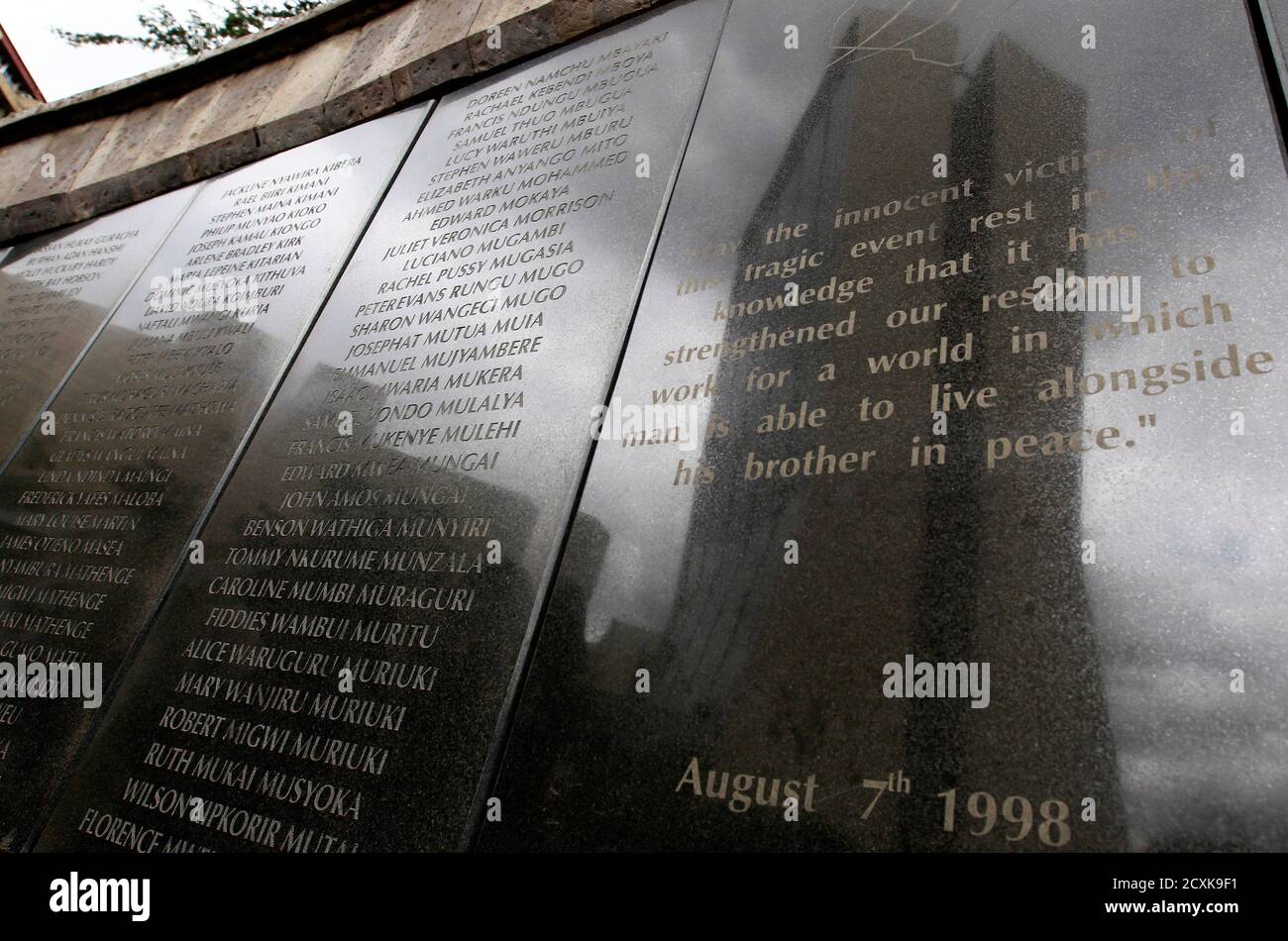 Les noms des 248 personnes tuées lors du bombardement de l'ambassade des États-Unis en 1998 sont visibles sur le mur commémoratif à Nairobi le 2 mai 2011. Selon les responsables, le dirigeant d'Al Qaïda, Osama ben Laden, a été tué dans un raid en hélicoptère américain dans un manoir près de la capitale pakistanaise, Islamabad, tôt lundi, mettant fin à une chasse mondiale de près de 10 ans pour le cerveau des attentats du 11 septembre. Le bâtiment de la Coopérative Bank, qui a également été endommagé lors des attentats à la bombe par camion du 7 août 1998 visant les ambassades américaines au Kenya, se reflète sur le mur commémoratif. REUTERS/Thomas Mukoya (KENYA - Tags: TROUBLES CIVILS POLITIQUE DE CONFLIT) Banque D'Images