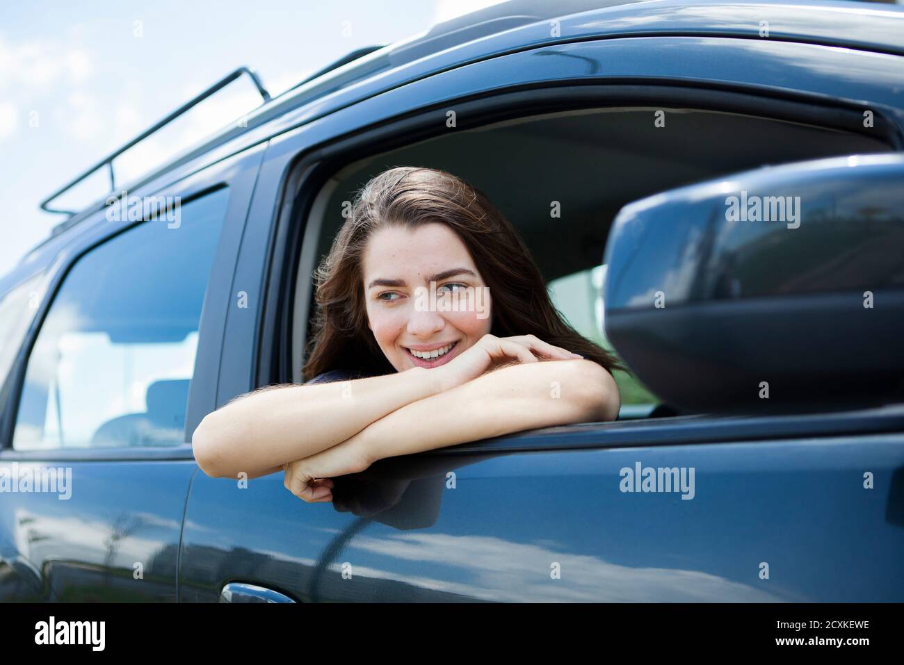 Belle jeune femme souriante assise en voiture Banque D'Images