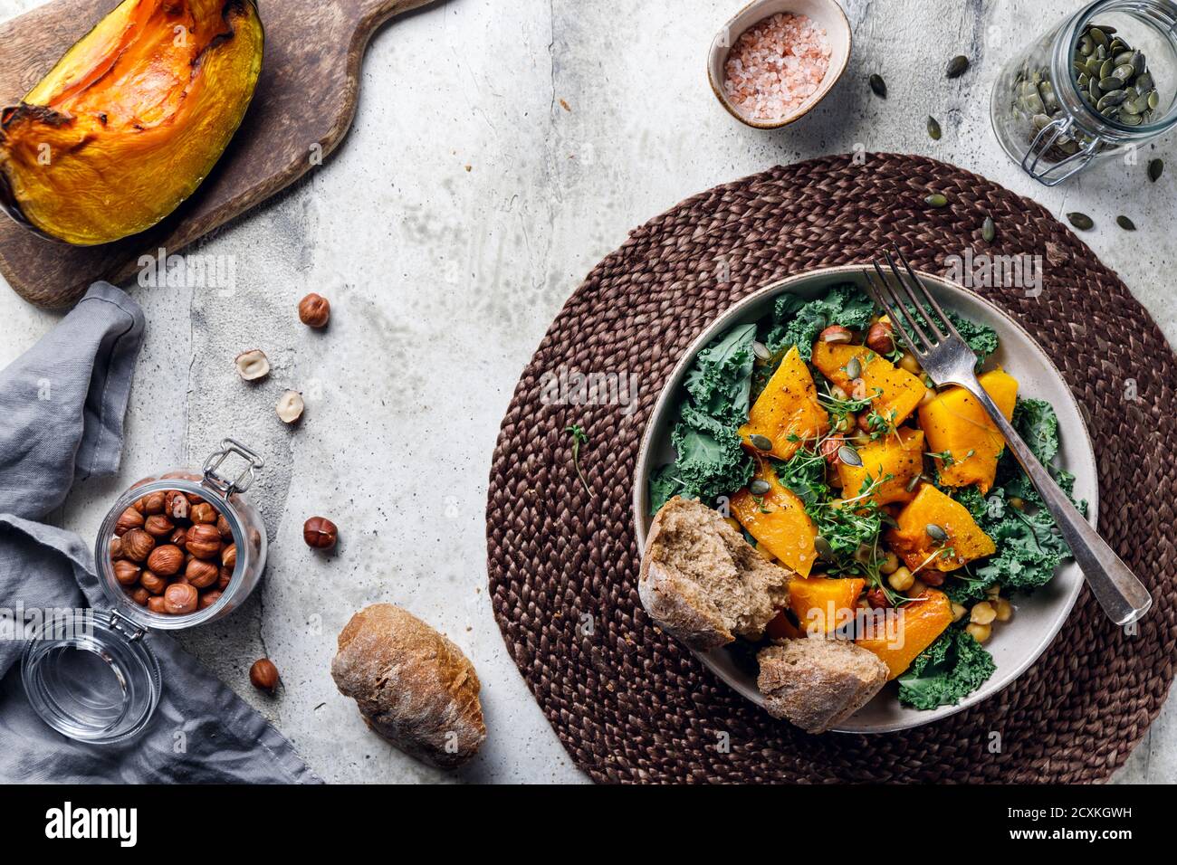 Vue de dessus de salade de saison avec citrouille grillée, chou frisé, pois chiches, pepitas et noix. Recette végétarienne d'automne saine. Banque D'Images