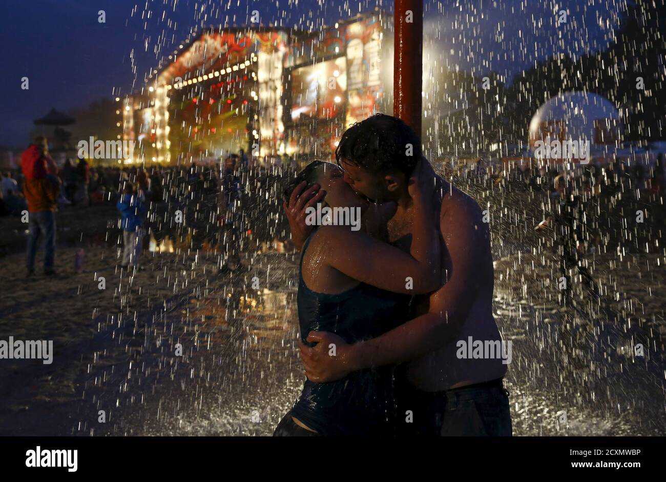Un couple s'embrasse en prenant une douche dans une fosse de boue près de  la scène principale pendant le 21e Festival de Woodstock à  Kostrzyn-upon-Odra, Pologne le 31 juillet 2015. On estime