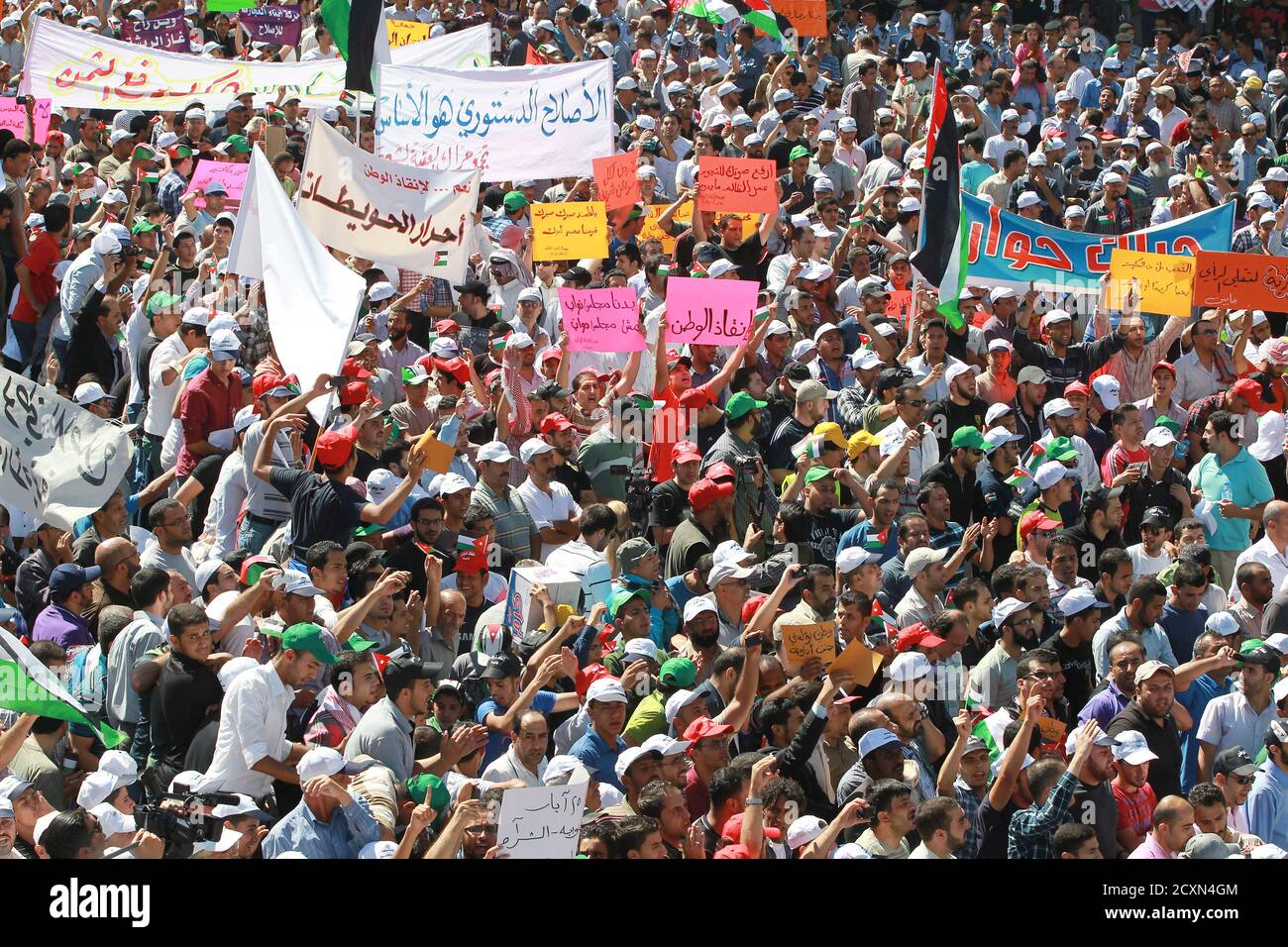 People from the Islamic Action Front and other parties hold signs as they demonstrate to demand political reforms, in Amman October 5, 2012. Thousands of Jordanian Islamist supporters marched on