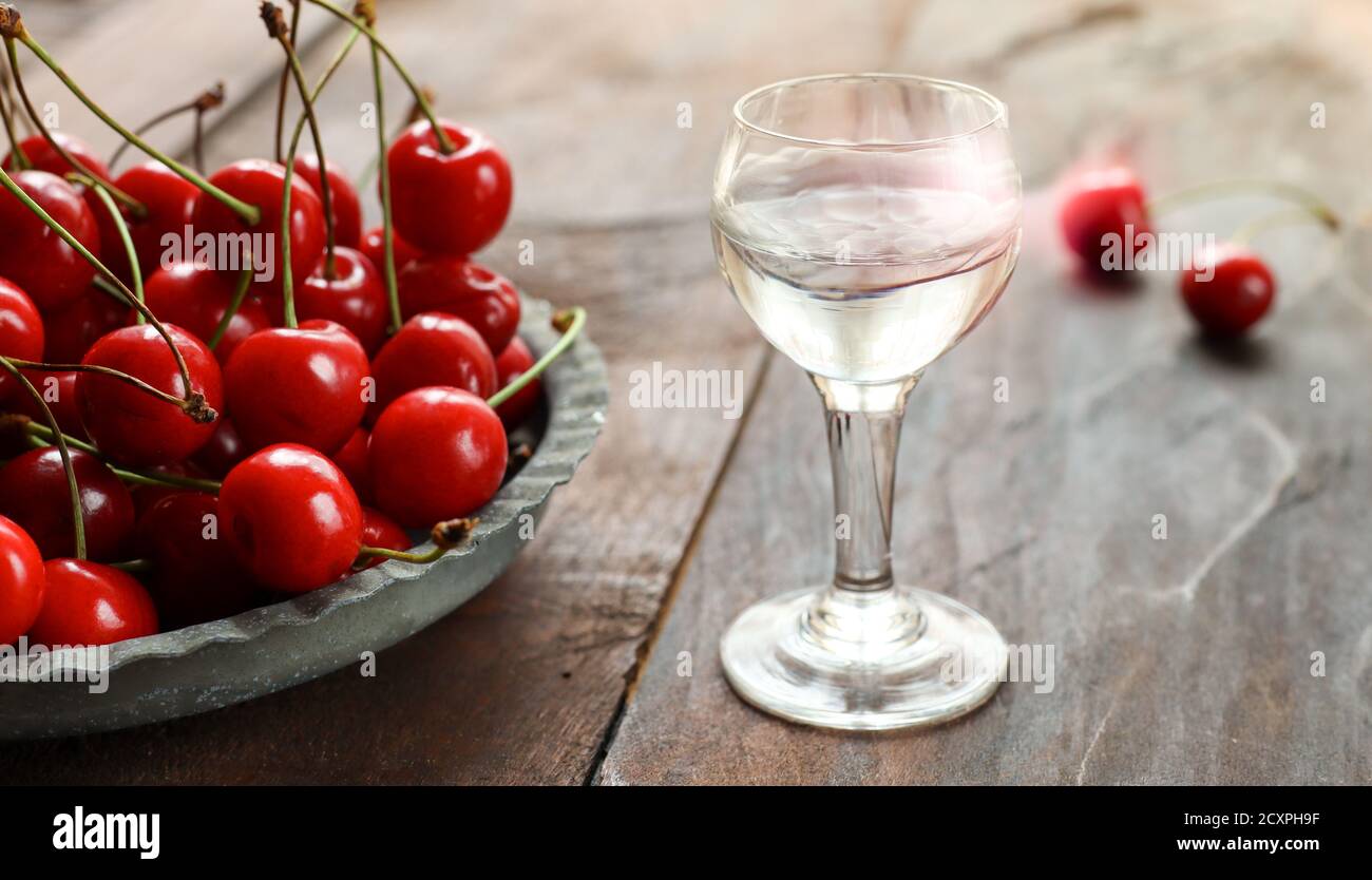Kirsch ou Kirschwasser - une forte boisson alcoolisée de cerise dedans un  verre et une cerise fraîche sur un vieux bois sombre tableau Photo Stock -  Alamy