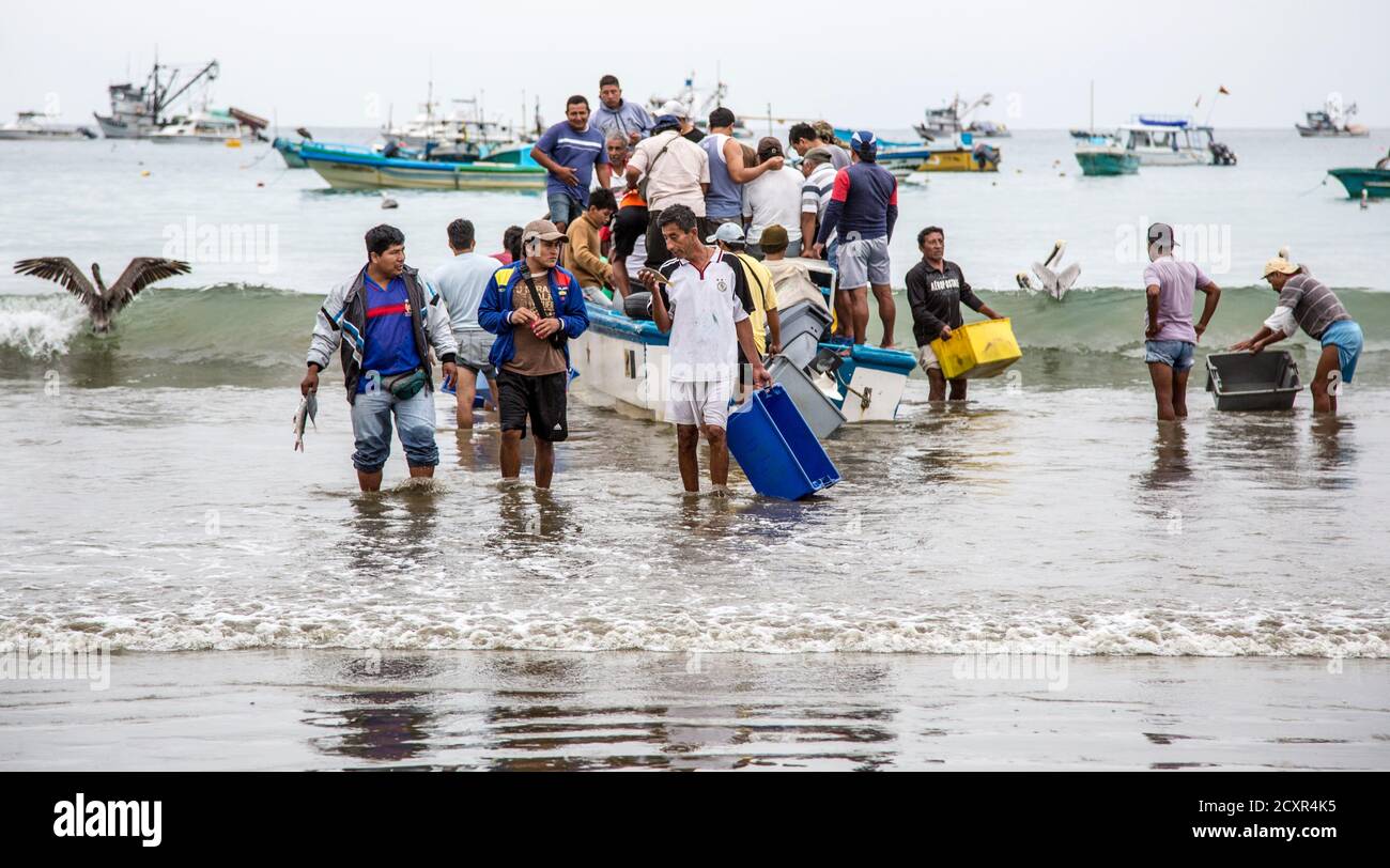 Puerto Lopez, ÉQUATEUR - Nov 26, 2012 : l'essaim des travailleurs petit bateau de pêche pour décharger ses prises Banque D'Images