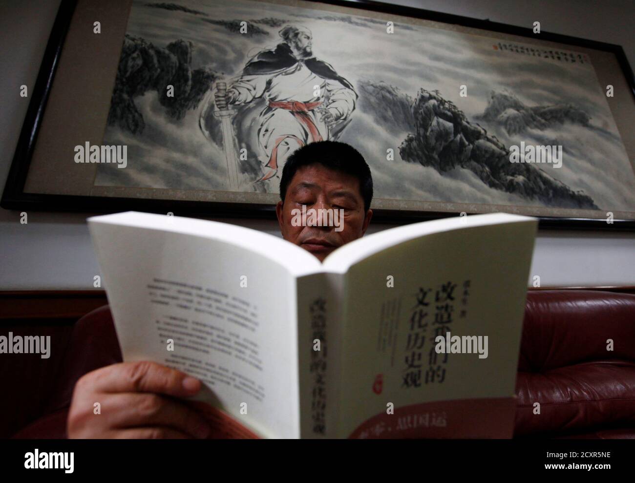 Retired Chinese Official And Author Zhang Musheng Poses For A Photograph  With His New Book 