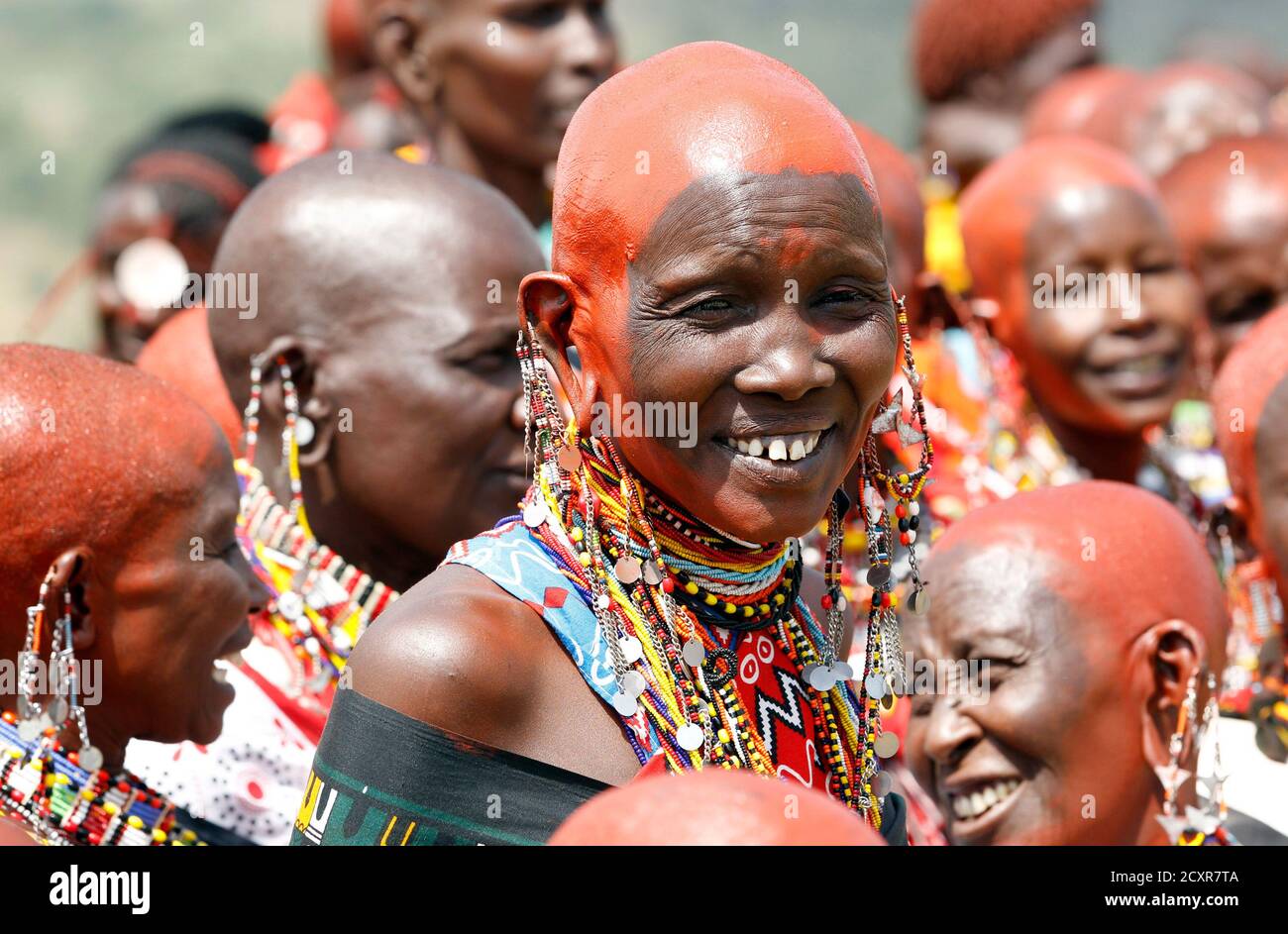Une femme de Maasai, avec son visage décoré d'ocre rouge, sourit alors qu'elle assiste à la préparation de 'Entoto', une cérémonie traditionnelle de l'âge à Olkerin Manyatta, dans le comté de Narok, à environ 108 km (67 miles) à l'ouest de la capitale du Kenya Nairobi, le 18 mars 2012. REUTERS/Thomas Mukoya (KENYA - Tags: SOCIÉTÉ) Banque D'Images