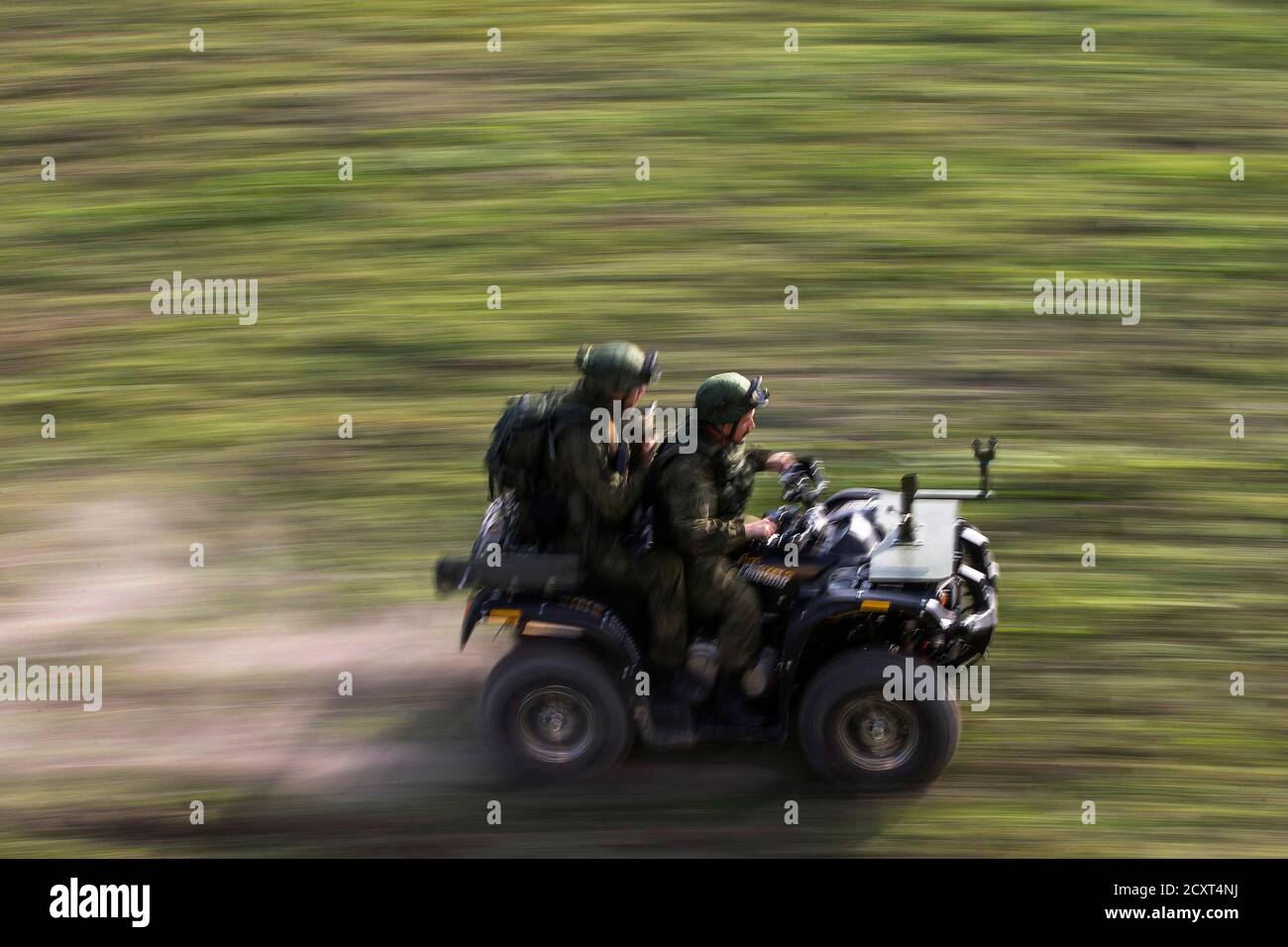 Russian soldiers ride on an all-terrain vehicle during a training exercise  in the village of Nikinci, west from Belgrade, November 14, 2014. Russian  soldiers parachuted into open fields in western Serbia on